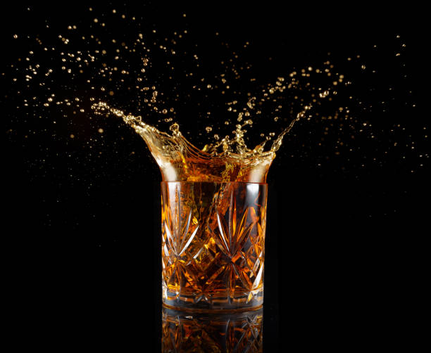 whisky cocktail splashing - whisky alcohol pouring glass foto e immagini stock