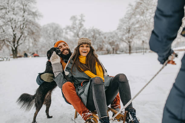 istock Couple in the snow play with dog 1129165472