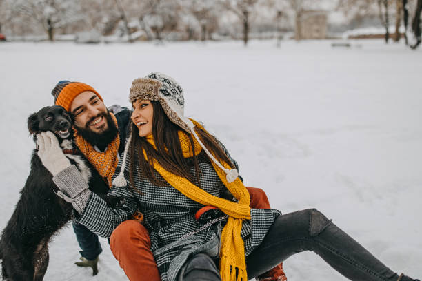istock Couple in the snow play with dog 1129165670