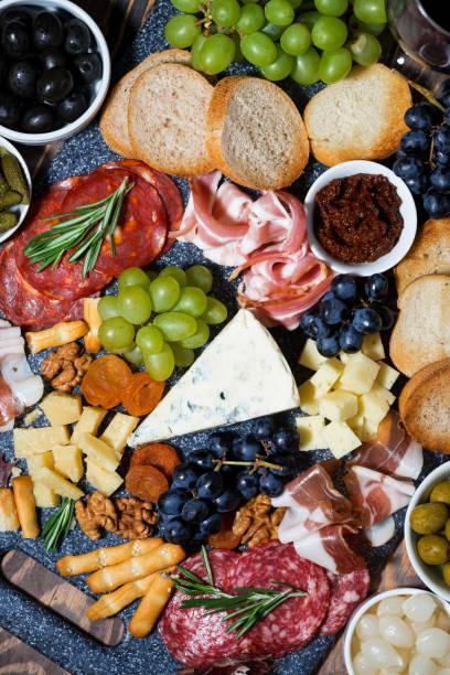 istock assorted gourmet cheeses and meats, vertical top view 1129167543