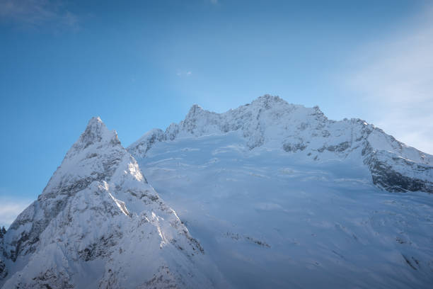 istock mountain peaks of Dombai mountains covered with snow surrounded by thick clouds 1129168590