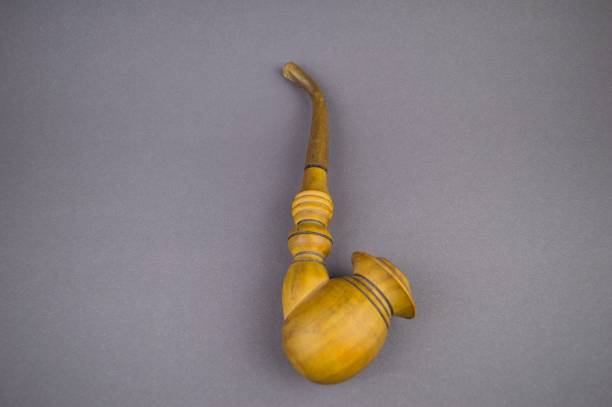 istock Wooden smoking pipe on a gray background with empty space to fill 1129168773