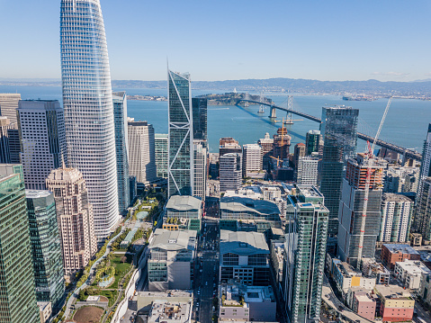 An aerial view of San Francisco skyline looking at Rincon Hill and the Salesforce Park. View includes a view of the 80 freeway, Bay Bridge and  San Francisco Bay.
