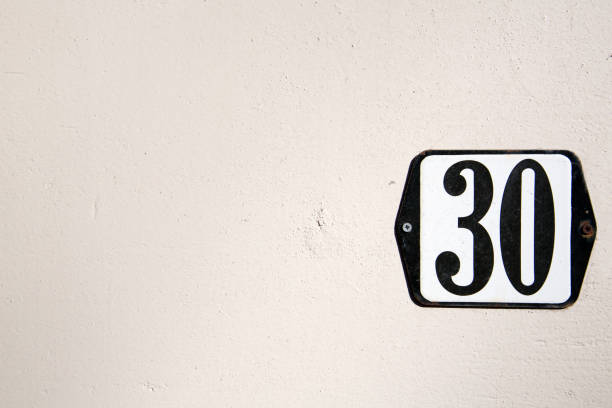 istock Number 30 tag on an off white plastered wall. 1129171812