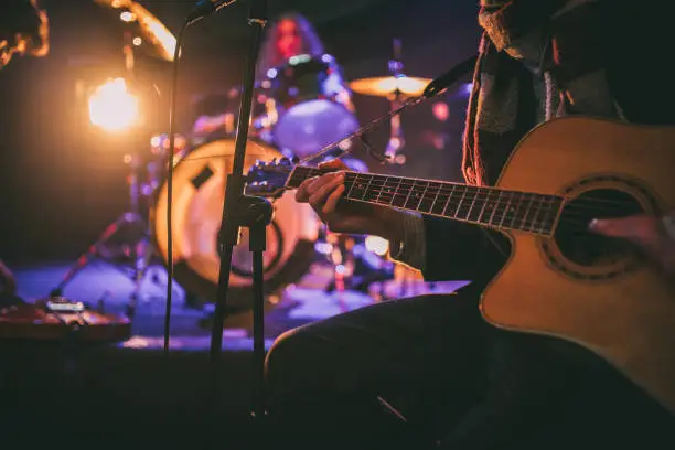 Musical band sitting on stage and having rehearsal