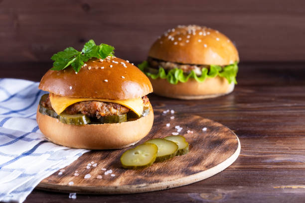 istock homemade hamburger with beef and cucumbers on wooden background 1129172089