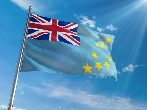 istock Tuvalu National Flag Waving on pole against sunny blue sky background. High Definition 1129173964