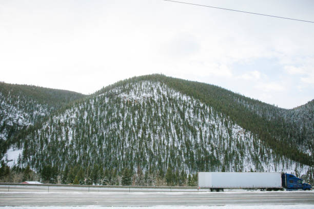 istock Semi Tractor Trailer Truck on a Snowy Mountain Highway 1129174041