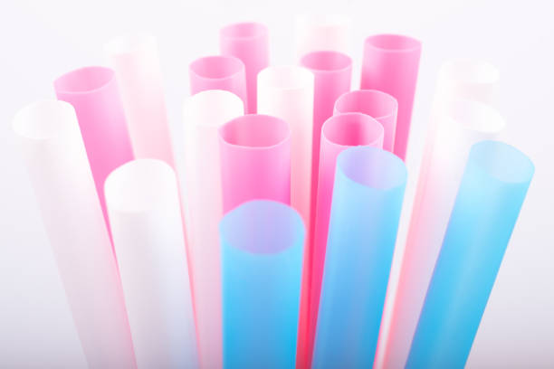 Colorful big plastic straws top view on a white background used as an accent . Earth movement, plastic recycling and refuge theme. Blue,pink,white color. Beyond Plastic.
