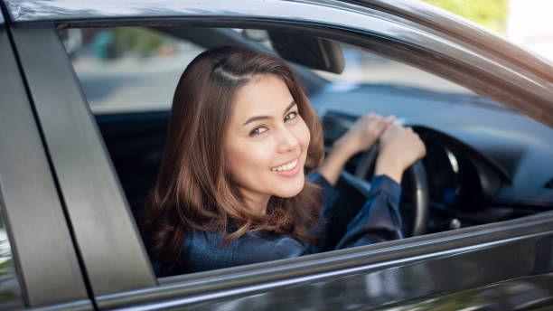 istock Beautiful woman is driving her car 1129176904
