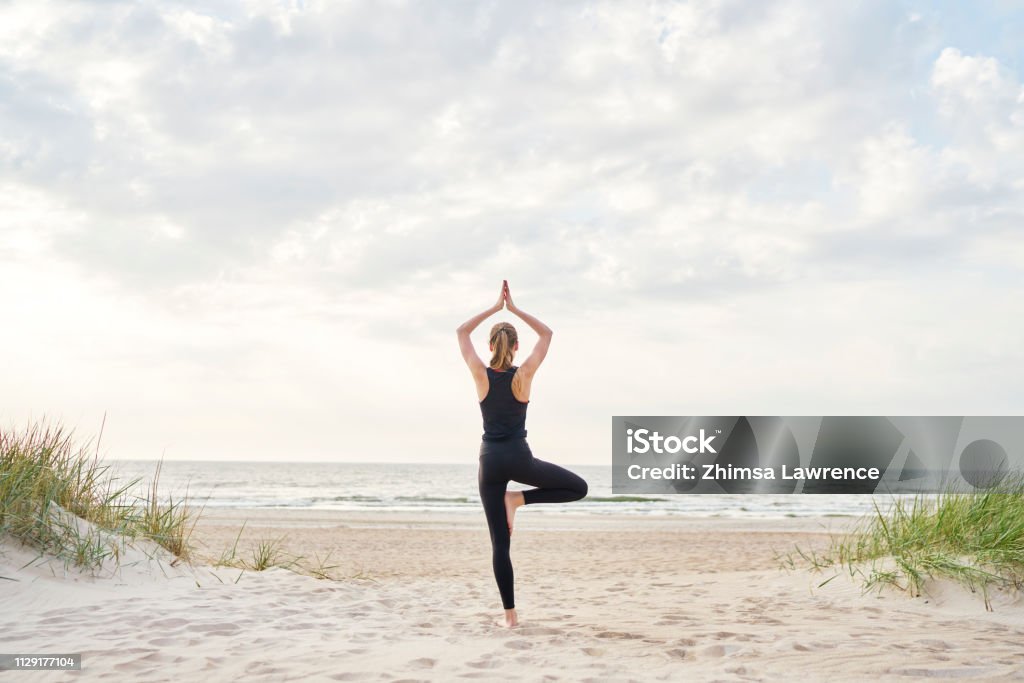 Junge Frau beim Yoga am Strand - Lizenzfrei Yoga Stock-Foto