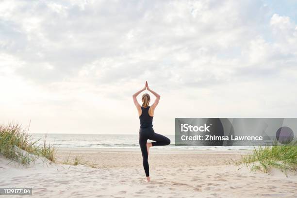 Junge Frau Beim Yoga Am Strand Stockfoto und mehr Bilder von Yoga - Yoga, Strand, Frauen