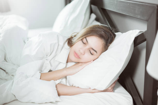 istock Beautiful woman sleeping on bed 1129177173