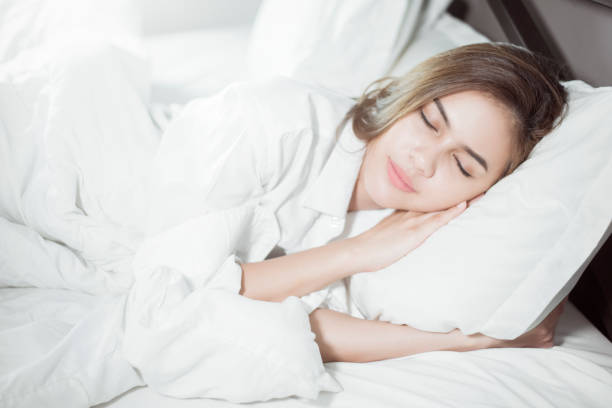 istock Beautiful woman sleeping on bed 1129177717