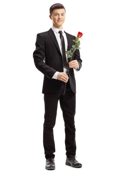 istock Young elegant man holding a red rose and smiling at the camera 1129178426