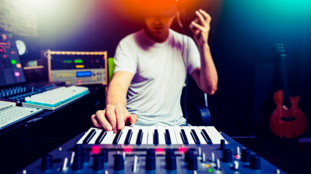asian male music producer, dj making electronic dance music in sound studio stock photo