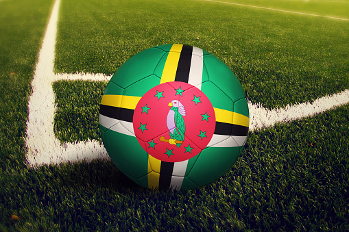 Dominica ball on corner kick position, soccer field background. National football theme on green grass.