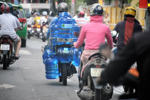 Vietnamese mother with school children riding a motorbike, South Vietnam