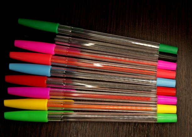 istock multi-colored pens on a dark wooden background arranged in a row 1129182494