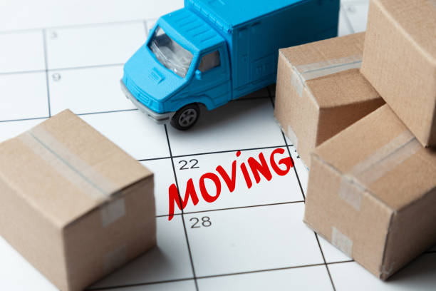 Moving day on the calendar is written in red. Calendar with a note with cardboard boxes and truck. Moving day on the calendar is written in red. Calendar with a note with cardboard boxes and truck company relocation stock pictures, royalty-free photos & images