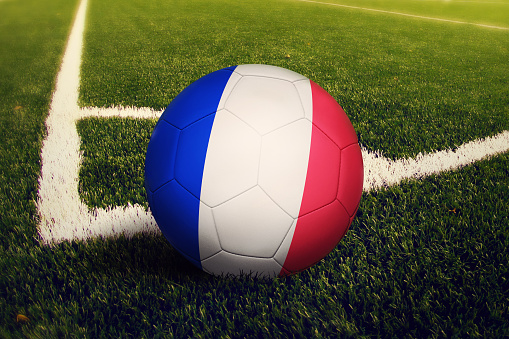France ball on corner kick position, soccer field background. National football theme on green grass.