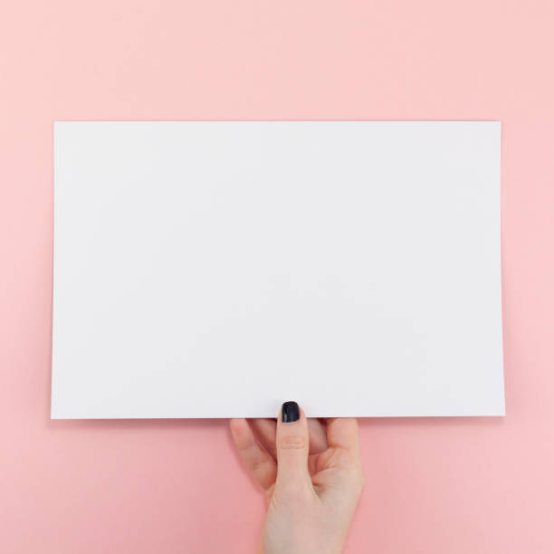 istock Woman hands with blank A4 paper sheet mockup 1129183804