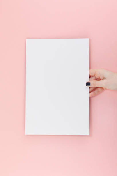 istock Woman hands with blank A4 paper sheet mockup 1129183809