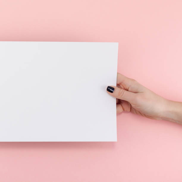 istock Woman hands with blank A4 paper sheet mockup 1129183812