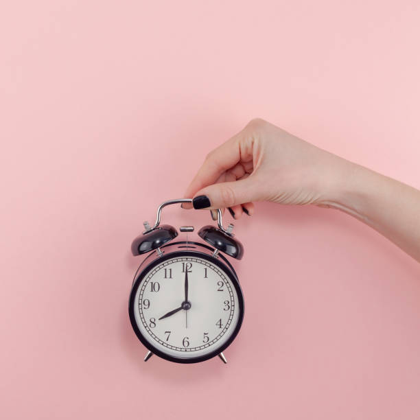 istock Female hand with alarm clock. Morning concept 1129183885