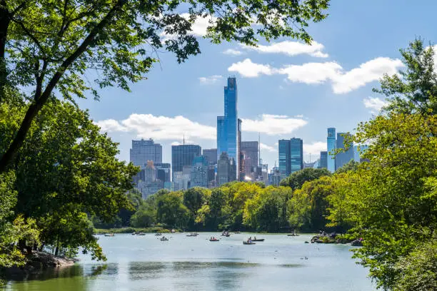 Photo of Unrecognizable people rowing in a lake during summer at Central Park, midtown Manhattan, New York City, USA.