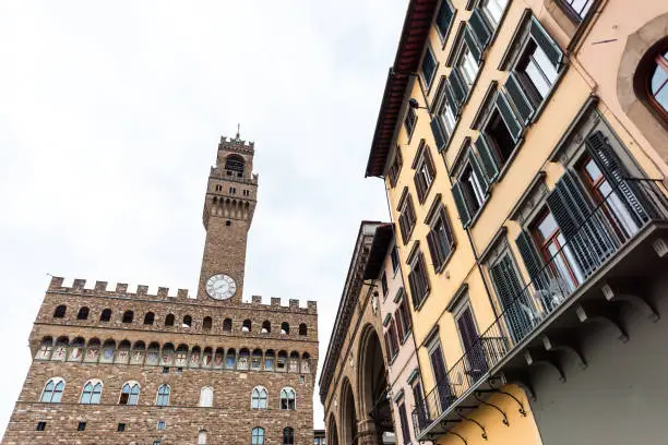 Firenze, Italy famous Florence view of old building Palazzo Vecchio in morning on cloudy day with clock time on Piazza della Signoria