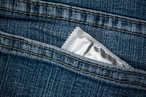 préservatif dans la poche de jeans bleu - sex condom jeans horizontal photos et images de collection