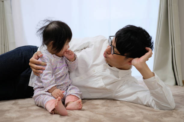 istock Husband playing with baby at home 1129189323