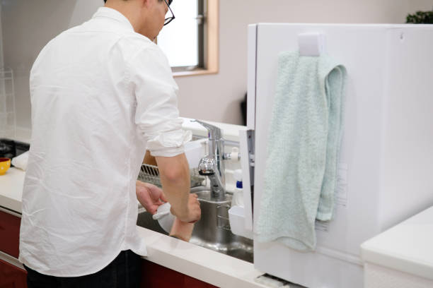 istock Man washing dish in kitchen 1129189356