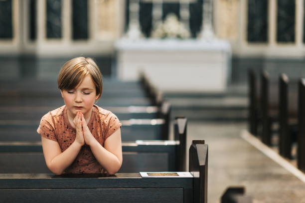 kleiner junge in der kirche beten - praying joy indoors lifestyles stock-fotos und bilder