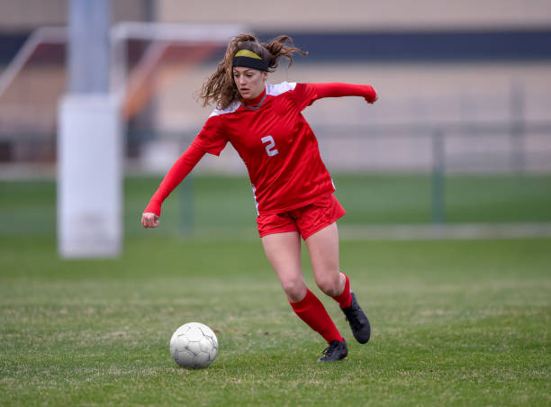 istock High School girl playing soccer 1129189717