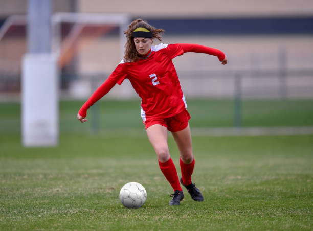 istock High School girl playing soccer 1129189719