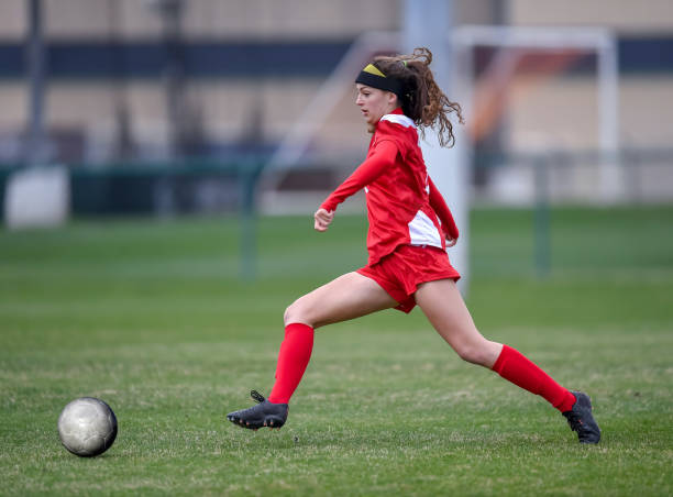 istock High School girl playing soccer 1129189720