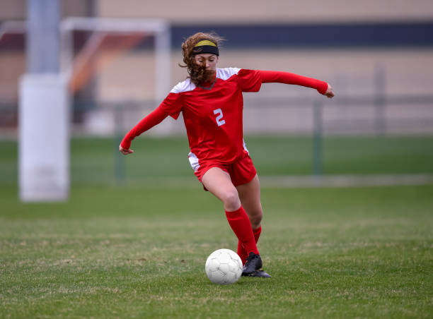istock High School girl playing soccer 1129189724