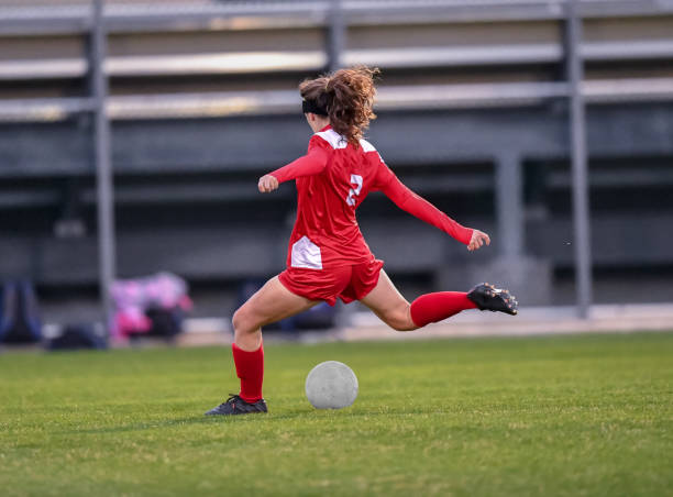 istock High School girl playing soccer 1129189750