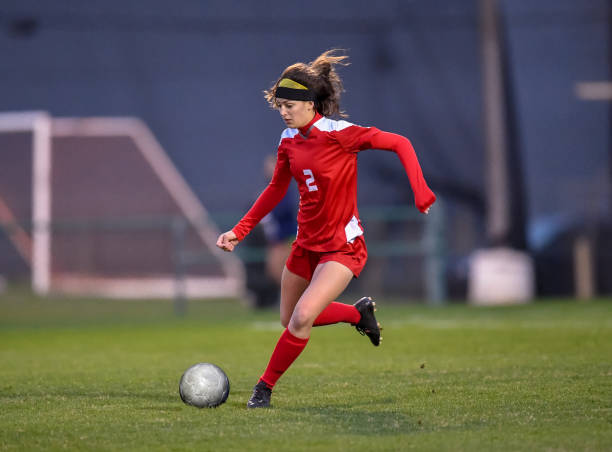 istock High School girl playing soccer 1129190315