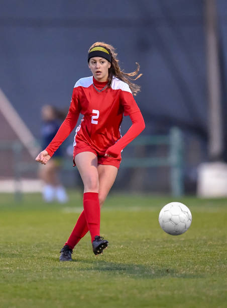 istock High School girl playing soccer 1129190316