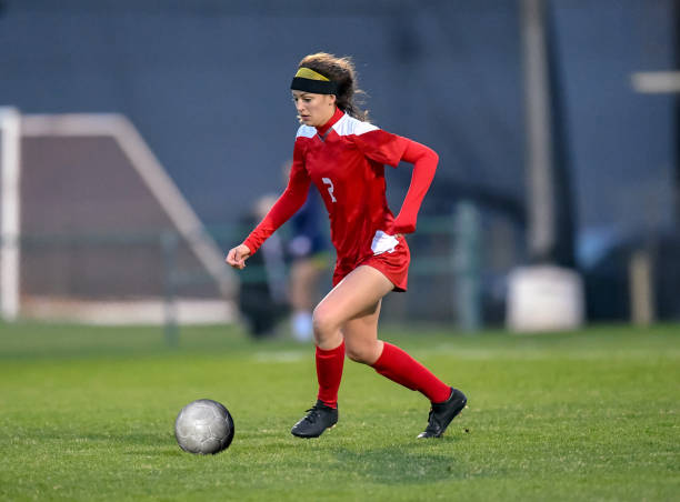 istock High School girl playing soccer 1129190330