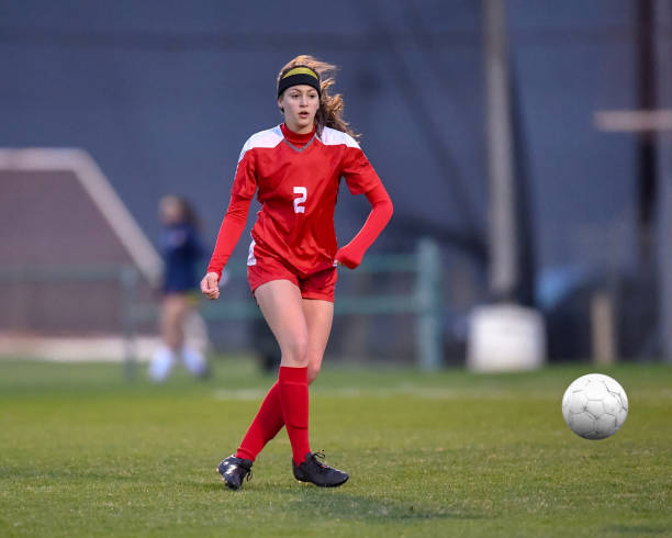 istock High School girl playing soccer 1129190345