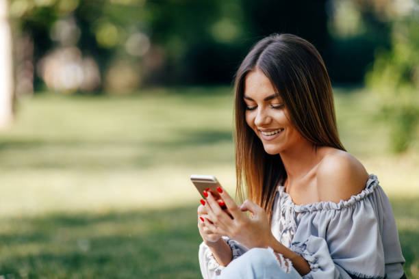 istock Young woman using a smartphone in the park 1129190747
