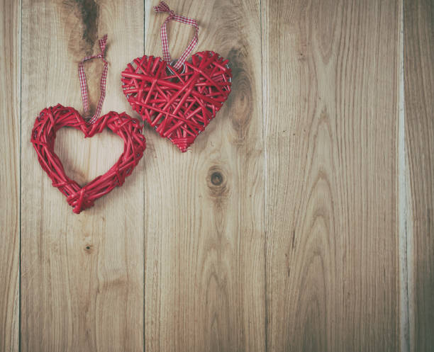 istock two red hearts on a wooden background of oak boards 1129190817