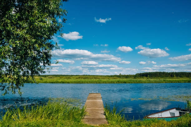 River Landscape with old wooden pier and a boat by the river