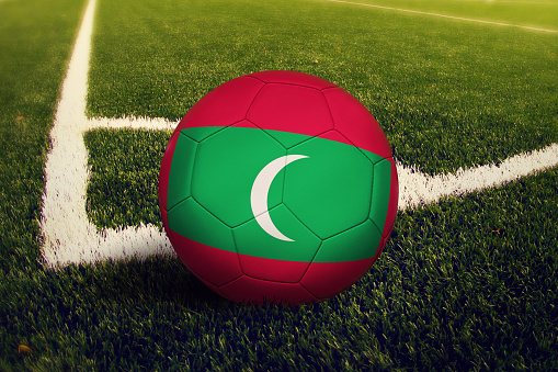 Maldives ball on corner kick position, soccer field background. National football theme on green grass.