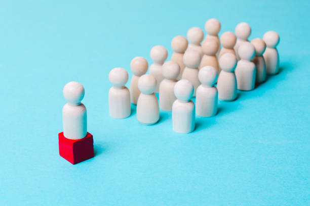 istock Wooden figures on a blue background. Leader and team. 1129195561