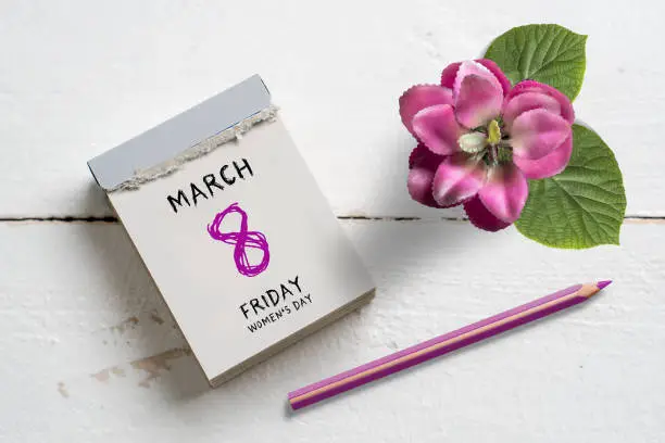 Tear-off calendar with International Women's Day 2019 on top on wooden background